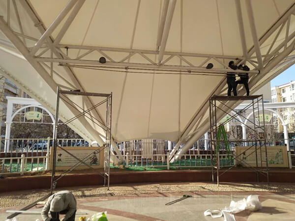 工人們對(duì)投影幕布進(jìn)行固定